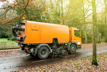 BADEN, BADEN, GERMANY - NOV 20, 2014: Orange Bucher CityFant 60 street sweeper machine cleaning the street after in fall from fallen foliage on a sunny dayのeditorial素材