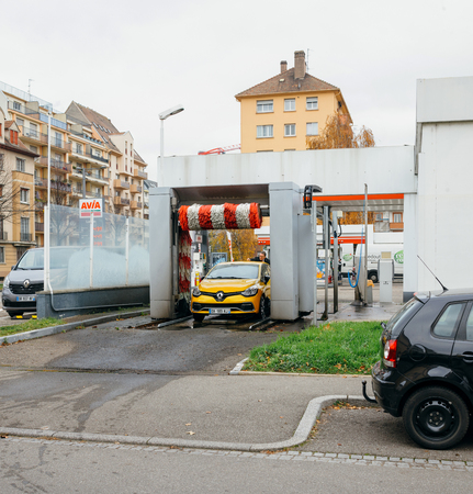STRASBOURG, FRANCE - DEC 2, 2016: Man attaching antenna to his yellow Renault sport car after using automatic car wash in cityのeditorial素材