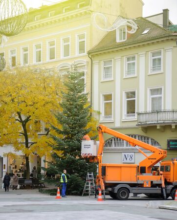 BADEN, GERMANY - NOV 20, 2015: Working hard for installation of Christmas decorations and Christmas tree in the center of Baden-Baden, Germanyのeditorial素材