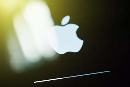 PARIS, FRANCE - SEPTEMBER 18, 2014: White Apple logo on Retina iPad Air display with update bar during iOS 8 update process with sun flare on the displayのeditorial素材