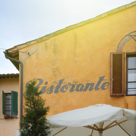 Beautiful Italian Restaurant sign (Ristorante) on a building with typical Tusacany yellow color. の写真素材