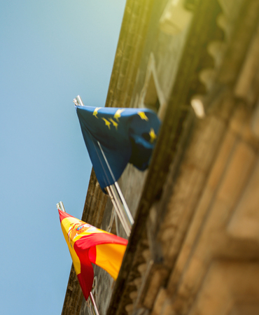 Spanish flag and European Union flag on a public building in Barcelona, Spainの写真素材