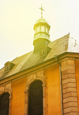 Urban ornated church cross on top of catholic cathedral on a sunny dayの写真素材