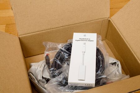 PARIS, FRANCE - SEP 12, 2016: White digital computer cable for thunderbot to ethernet cable with Ethernet cable insinde Amazon Prime cardboard box after unboxingのeditorial素材
