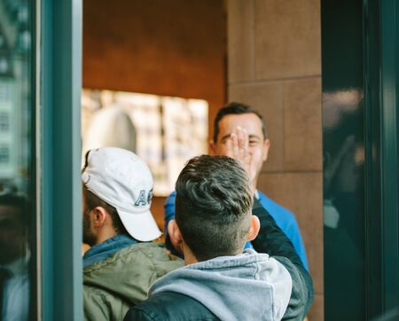 STRASBOURG, FRANCE - SEPTEMBER 19, 2014: Apple Store employee giving five and welcoming customers waiting in line outside the front the store during the sales launch of the new iPhone smartphoneのeditorial素材