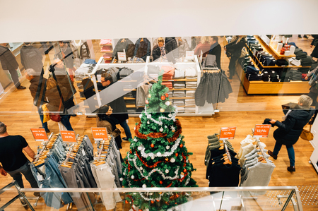 STRASBOURG, FRANCE - DEC 9, 2016: View from the street of clothing shop with Christmas tree and people buying giftsのeditorial素材