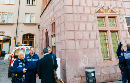 MULHOUSE, FRANCE - DEC 12, 2015: Police officers surveilling the entrance gate with neon Christmas decorations of the Christmas Market in Strasbourg with high grade security after Paris attacksのeditorial素材