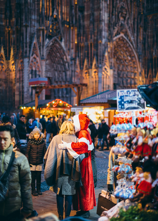 STRASBOURG, FRANCE - DEC 20, 2016: Woman taking photograph with Santa during Christmas Market in front of the Cathedral Notre-Dame in Strasbourg, Alsaceのeditorial素材
