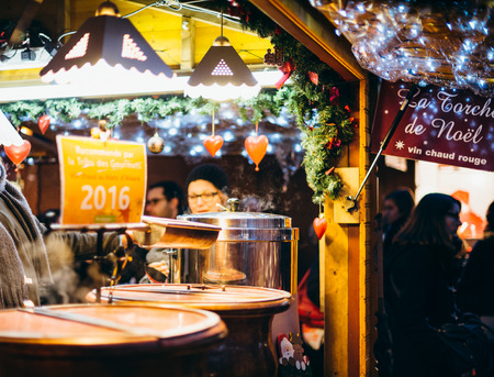 STRASBOURG, FRANCE - DEC 20, 2016: Customers drinking hot Christmas wine at the traditional market stall while visiting the oldest Christmas Market worldwide in central Strasbourg, Alsaceのeditorial素材