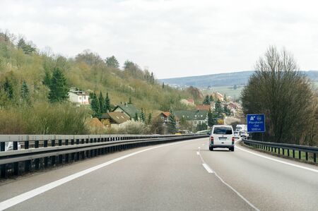 GERMANY - MAR 26, 2016: Driver point of view pov of white Volkswagen van driving on German Autobahn Bundesautobahn or Federal Motorway highway with speed limits of 100 kmh electronic street signのeditorial素材