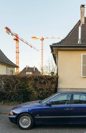 STRASBOURG, FRANCE - NOV 29, 2016: Blue BMW luxury limousine sedan parked in city with luxury real estate building in the background and cranes working in the backgroundのeditorial素材