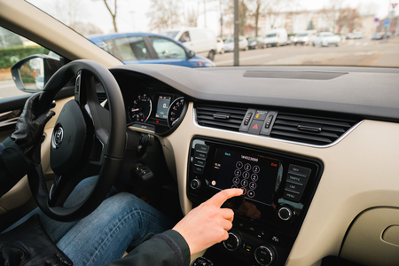 PARIS, FRANCE - DEC 13, 2016: Woman driving dialing number on the Apple CarPlay main screen in modern car dashboard. CarPlay is an Apple standard that enables a car radio or head unit to be a display and controller for an iPhone. It is available on all iPのeditorial素材