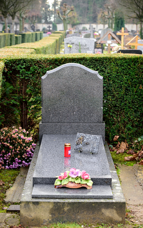 Gray marble tombstones in French cemetery with beautiful crafted crossの写真素材