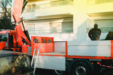 Boom truck in operation with workers looking from the truck platform for best guidance serviceの写真素材