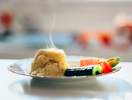 Couscous hot steaming on a plate with fresh vegetables - organic food ready to eat の写真素材