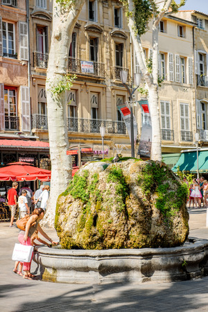 AIX-EN-PROVENCE, FRANCE - JUL 17, 2014: Mother and daughter having fun at the fountain stone in center of Aix-En-Provence on a warm summer day enjoying the atmosphere on Boulevard Napoleonのeditorial素材