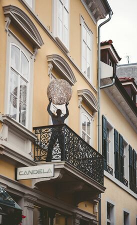 BADEN-BADEN, GERMANY - NOV 20, 2014: Abstract sculpture statue with man holding light ball on a balkony in central Baden-Baden, Germany on Merkurstrassのeditorial素材