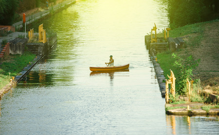 STRASBOURG, FRANCE - AUG 5, 2015: Man kayaking canoeing in Ill River next to European Parliament in Strasbourg  on a warm summer day.のeditorial素材