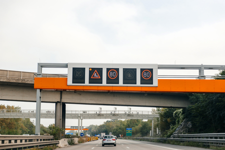 VIENNA, AUSTRIA - SEP 30, 2014: Driver POV point of view of electronic highway overhead Slow down sign due to construction works on Austrian autobahnのeditorial素材