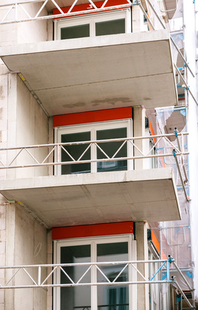 Modern apartment construction with new PVC windows and protection fence for the workersの写真素材