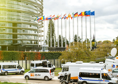 STRASBOURG; FRANCE - OCT 7; 2015: Tv Television Trucks with multiple Satellite parabolic antennas and fiber optic cables going inside reporting live the official French president visit to the European PArliament in Strasbourg; France - everything surveillのeditorial素材