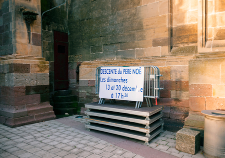 Translation from French - descent from the roof of santa claus during sunday's - special schedule event for kids during Christmas Market in France, Alsace Thann Saint-Theobald collegiate churchのeditorial素材