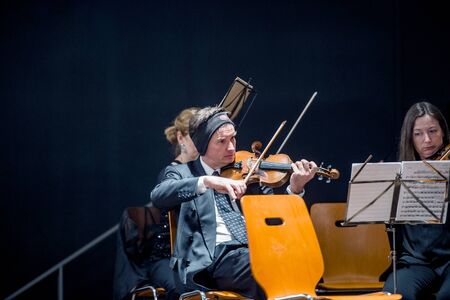 STRASBOURG, FRANCE - MAR 18, 2016: View through the window of a building - violonist perparing classical music orchestra for the concert in Strasbourg, Franceのeditorial素材