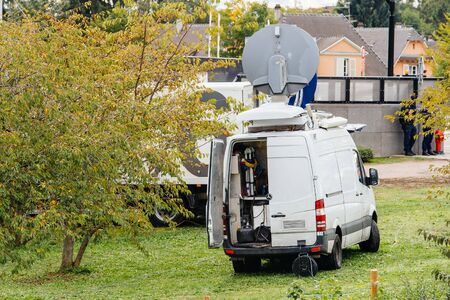 Rear view of white Tv Television Trucks with multiple Satellite parabolic antennas and fiber optic cables going inside reporting live the official French president visit to the European Parliament in Strasbourg, Franceのeditorial素材
