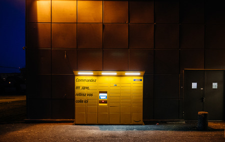 PARIS, FRANCE - FEB 15, 2017: Front view of Amazon locker orange delivery package locker at dusk - Amazon Locker is a self-service parcel delivery service offered by online retailer Amazon.com. Amazon customers can select any Locker location as their deliのeditorial素材