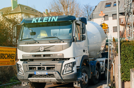 STRASBOURG, FRANCE - MAR 13, 2017: Front view of Volvo FMX truck with Liebherr cement mixer instalation working at the construction site on  tiny French streetのeditorial素材
