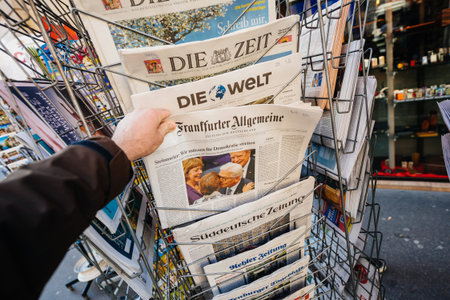 PARIS, FRANCE - MAR 23, 2017: Man purchases a German Frankfurter Allgemeine Zeitung newspaper from...