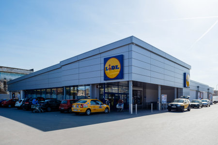 BUCHAREST, ROMANIA - MAR 24, 2016: Lidl supermerket entrance with trolleys, cars in parking and...