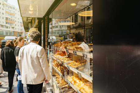 BUCHAREST, ROMANIA - MAR 21, 2016: Customers admiring selection of typical street food in Bucharest Romania bakery selling placinte other pastries with customers waiting the hot and delicious foodのeditorial素材