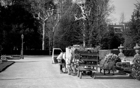 STRASBOURG, FRANCE - APR 12, 2016: Rear view of gardeners working near van with carriage trailer transporting toward destination new fresh flowers, tree and bushes for the green spring parkのeditorial素材