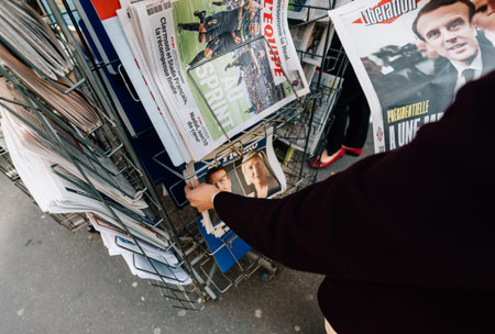 PARIS, FRANCE - APRIL 24: Woman buy looks at press kiosk at French newspaper  with pictures of...