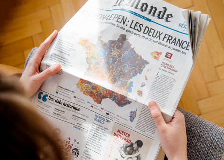 PARIS, FRANCE - APR 24, 2017: POV above French map electins result on newspaper cover - woman reading the French newspaper Le Monde a day after the first round of the French Presidential election on April 24, 2017のeditorial素材