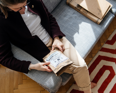 PARIS, FRANCE - APR 24 2017: Multiple Amazon boxes woman unpacking unboxing Amazon cardboard box with logotype printed on cardboard box side. Amazon Inc is the an American electronic e-commerce shopping companyのeditorial素材