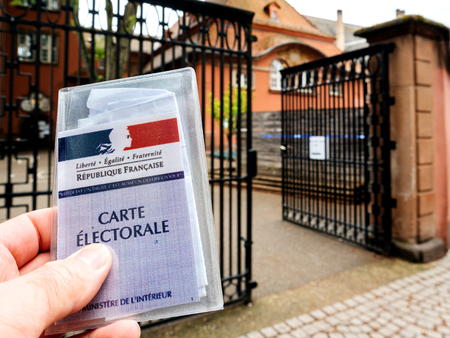 STRASBOURG, FRANCE - MAY 7, 2017: Man holding Carte Electorale - voter's card French voter registration card in front of polling station during the second round of the French presidential election to choose between Emmanuel Macron and Marine Le Penのeditorial素材
