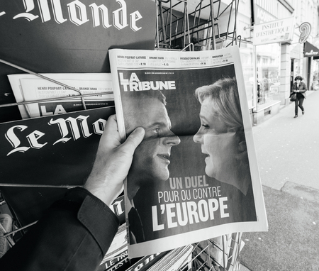 PARIS, FRANCE - MAY 9, 2017: Pov buying La Tribune newspaper front page with the picture of the newly elected French president Emmanuel Macron and Le Pen after the second round French Presidential electionのeditorial素材