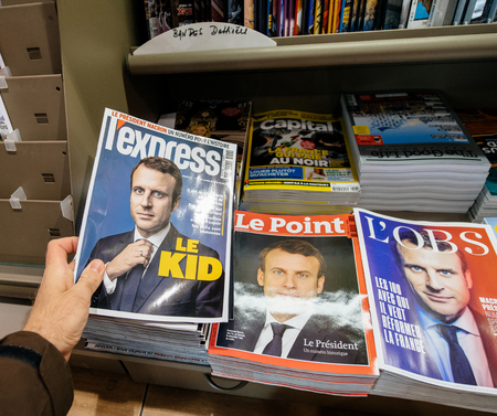 PARIS, FRANCE - MAY 9, 2017: Pov buying magazines L`Express and Le Point with front page of the newly elected French president Emmanuel Macron second round French Presidential electionのeditorial素材