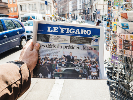 PARIS, FRANCE - MAY 15, 2017: POV over Le Figaro an buys newspaper reporting handover ceremony presidential inauguration of the newly elected French President Emmanuel Macron in Paris, Franceのeditorial素材