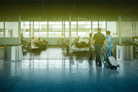 FRANKFURT, GERMANY - JUL 3, 2015: Interior of Frankfurt airport with family senior people waiting for their airline, walking with trolley luggage, delayed flight or plane arrival departureのeditorial素材