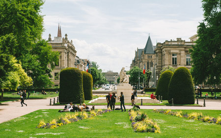 STRASBOURG, FRANCE - MAY 18, 2016: People having fun in Place de la Republique Park near the  Palais du Rihn Palace of the Rhine the former Kaiserpalast (Imperial palace) with  Avenue de la Liberte and and University of Strasbourg building in the backgrouのeditorial素材