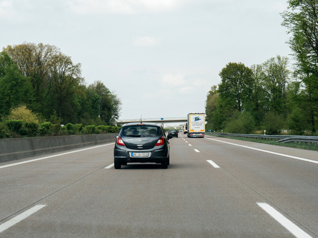 FRANKFURT, GERMANY - APR 13, 2017: Driver point of view pov of black Opel Corsa driving on German Autobahn Bundesautobahn or Federal Motorway highway with speed limits of 100 kmh electronic street signのeditorial素材