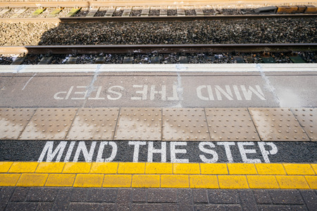 Directly above view of Mind the step yellow text line in British train station - visiting United kingdom taking care and security measures while traveling with trainの写真素材