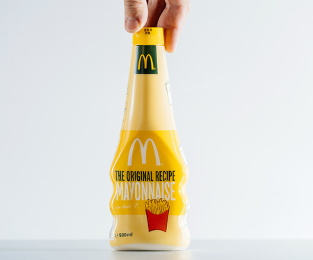 PARIS, FRANCE - JUL 30, 2017: McDonald The original recipe Mayonnaise pot in traditional yellow colors of the fast-food chain seen on the clean background held by a male handのeditorial素材