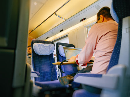 MUNICH, GERMANY - AUG 8, 2017: German worker insidefast ICE train commuting worker on laptop for the next important project - commuting home going to workのeditorial素材