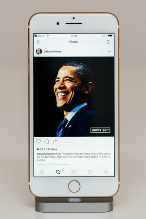 PARIS, FRANCE - SEP 26, 2016: New Apple iPhone 7 Plus in docking station after unboxing and testing by installing and running the app application software Barack Obama 55th anniversary photos on Instagram official accountのeditorial素材