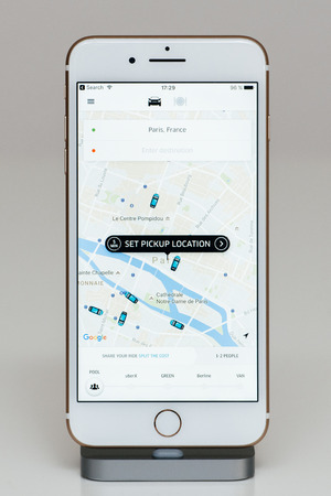 PARIS, FRANCE - SEP 26, 2016: New Apple iPhone 7 Plus in docking station after unboxing and testing by installing and running the app application software set pickup location for uber driver app transportaitonのeditorial素材