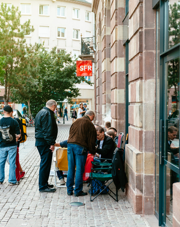 STRASBOURG, FRANCE - SEP 9, 2014: Customers waiting outside Apple Store prior the launch day of the newest iPhone Apple Watch iPad iMac computers - large Apple Store facade with computer Apple logotypeのeditorial素材